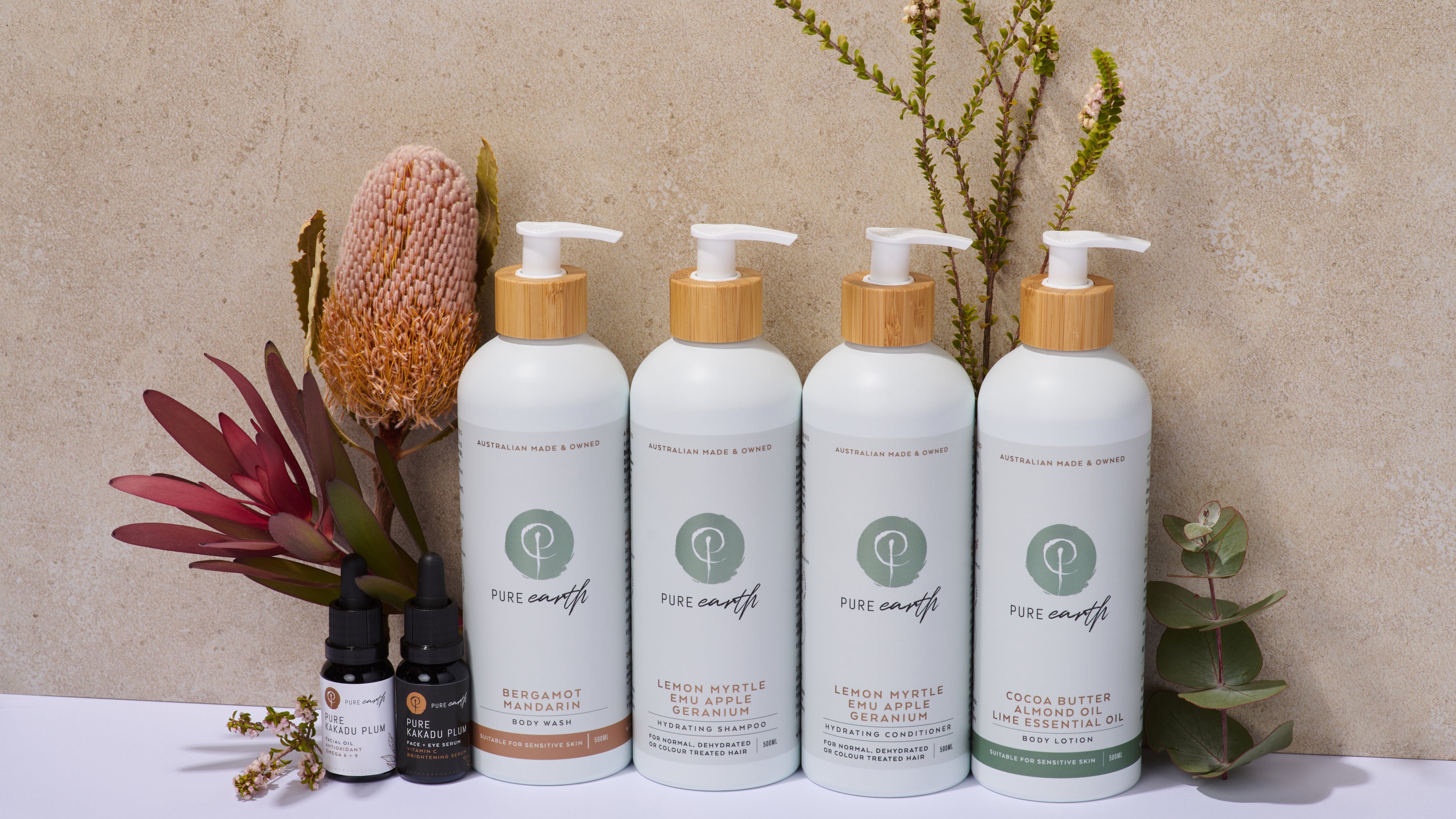 Set of Pure Earth skincare products including kakadu plum vitamin c and natural shampoo and conditioner on a neutral background with decorative plants.