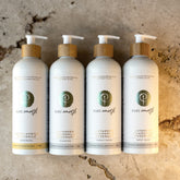 Four pure earth bottles including natural shampoo, natural conditioner, natural body wash and natural hand wash with beige background