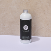 Bottle of Pure Earth deep repair hair treatment mask with aluminium cap on a beige background