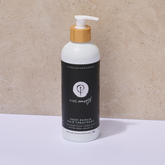 Bottle of Pure Earth deep repair hair treatment with a bamboo pump on a neutral background