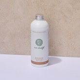 White bottle of Pure Earth Bergamot essential oil body wash on a beige background