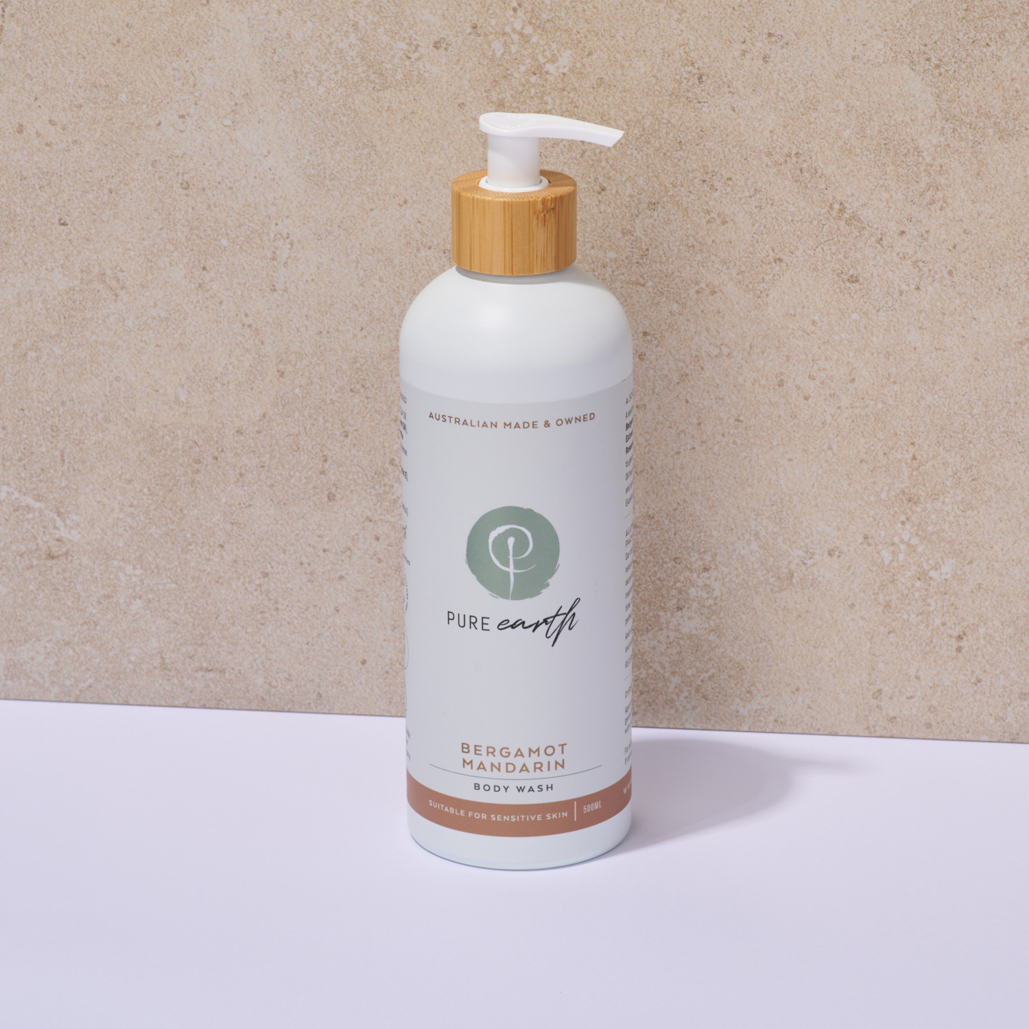 Bottle of Pure Earth body wash with bergamot and pump on a neutral background