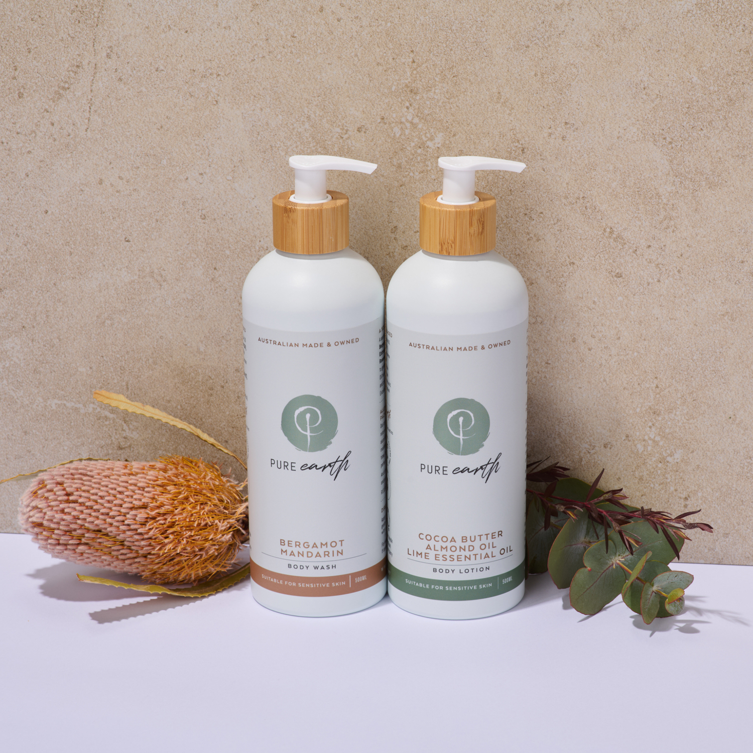 Two bottles of Pure Earth with body lotion and body wash on a neutral background with natural elements.