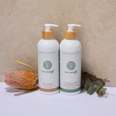Two bottles of Pure Earth with body lotion and body wash on a neutral background with natural elements.