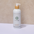 White Pure Earth natural body wash bottle with wooden pump on a beige background