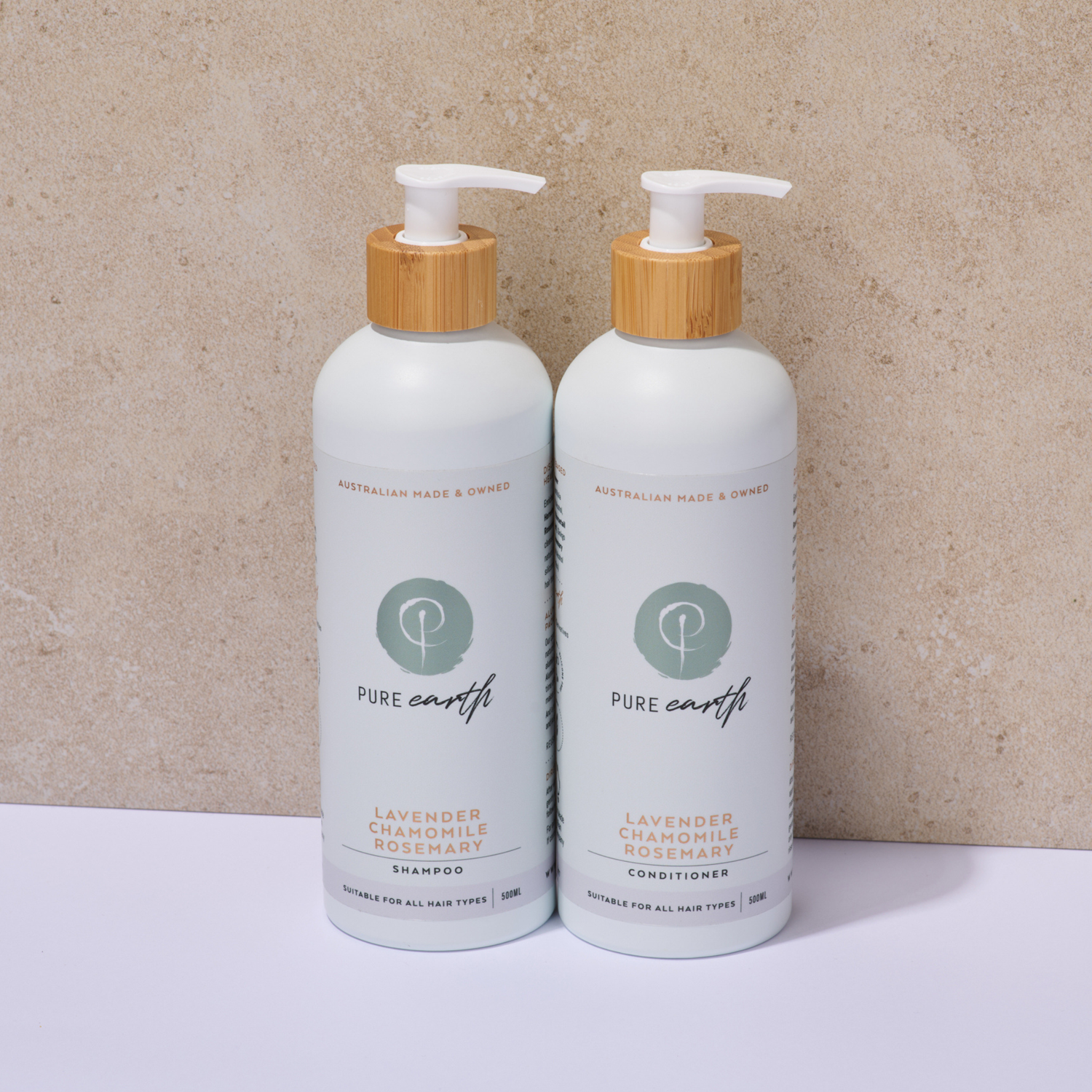 Two bottles of Pure Earth lavender chamomile shampoo and conditioner on a beige background