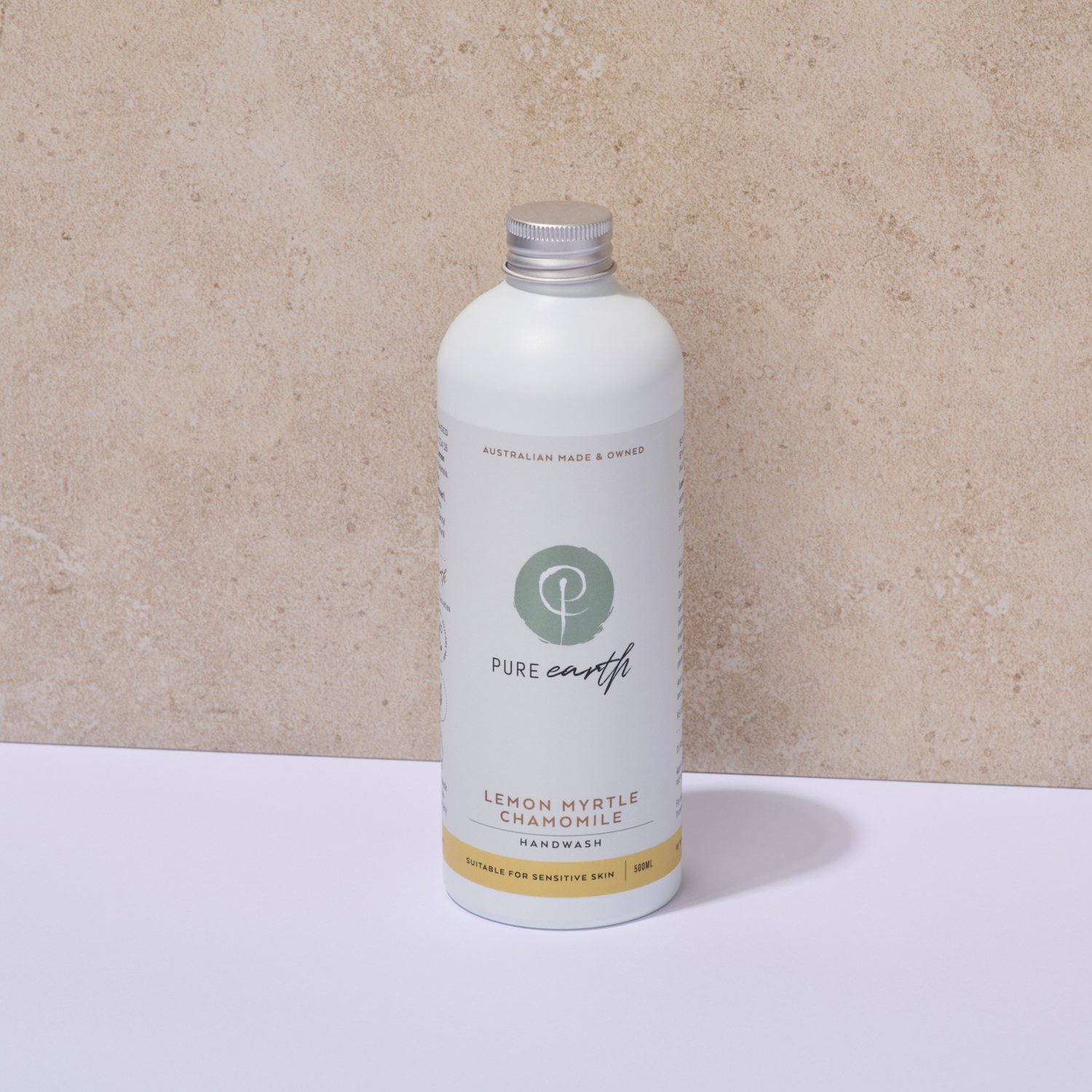 White Pure Earth bottle with a silver aluminium cap on a beige background