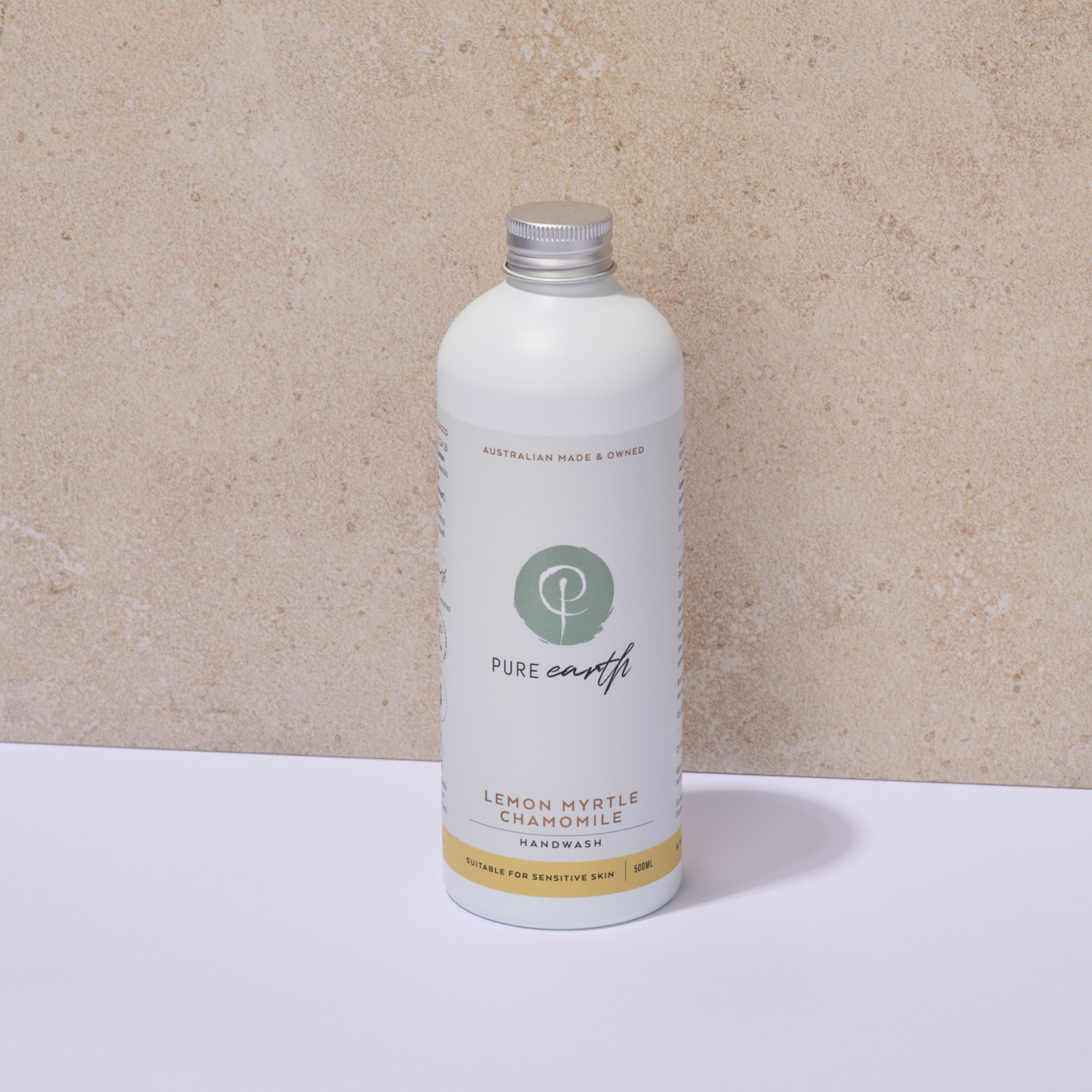 White Pure Earth bottle with a silver aluminium cap on a beige background