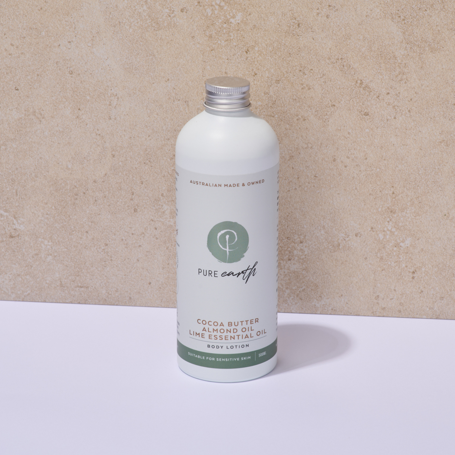 White bottle of Pure Earth body lotion on a beige background and aluminium cap
