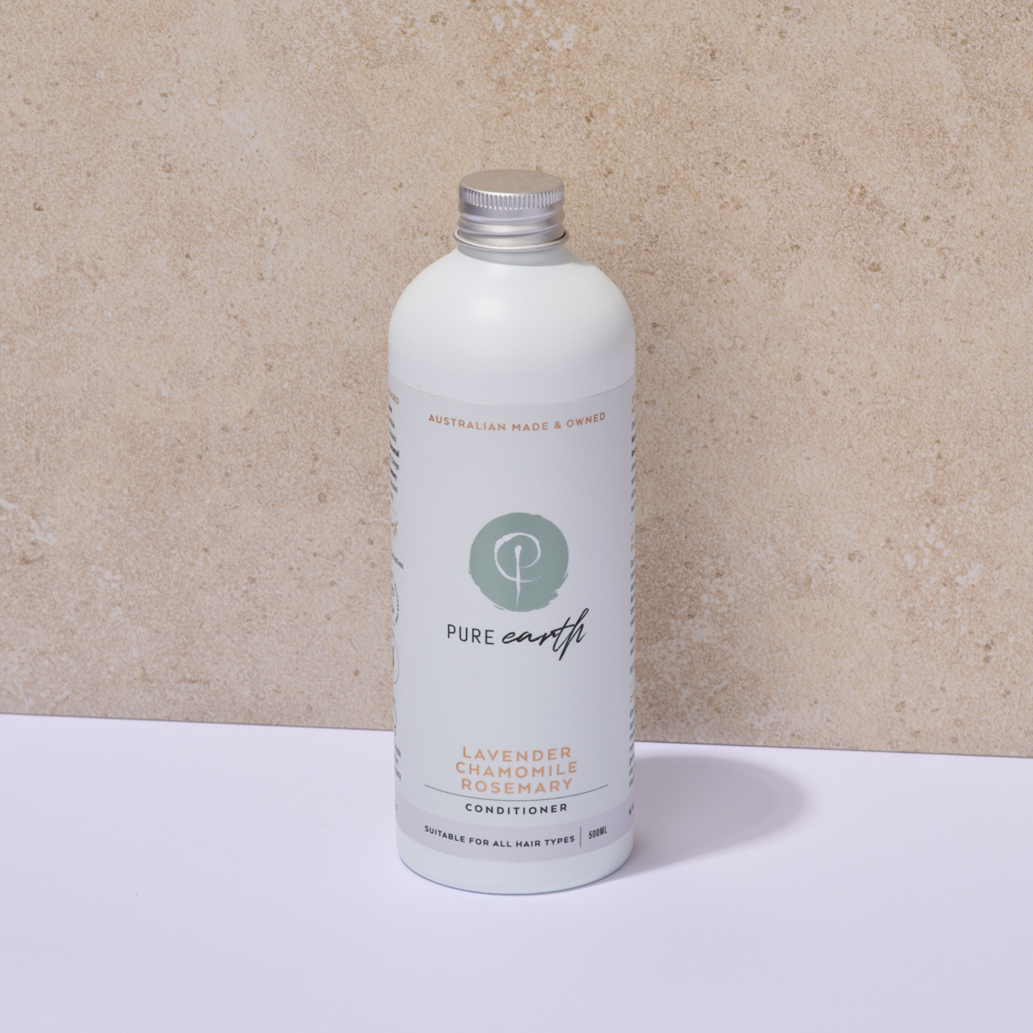 White bottle of Pure Earth naturla and gentle conditioner with aluminium cap on a beige background
