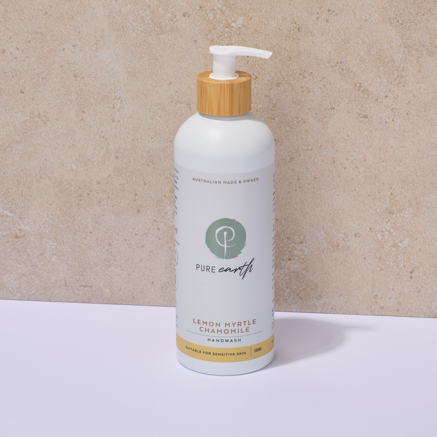 Bottle of Pure Earth lemon myrtle chamomile handwash with a wooden pump on a beige background