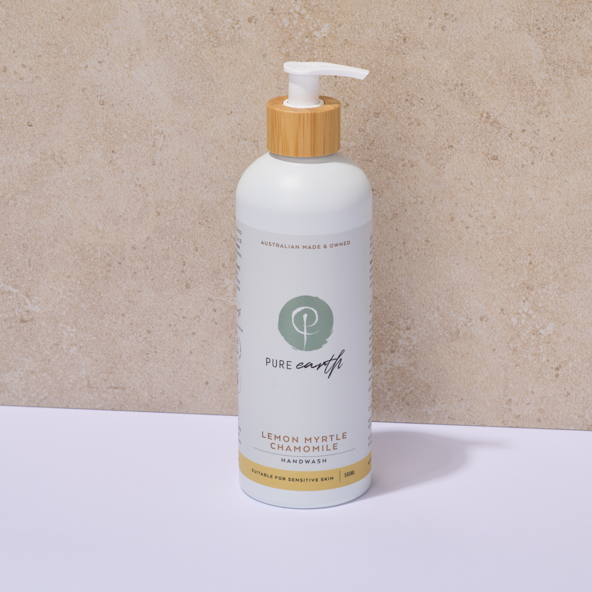 Bottle of Pure Earth lemon myrtle chamomile handwash with a wooden pump on a beige background