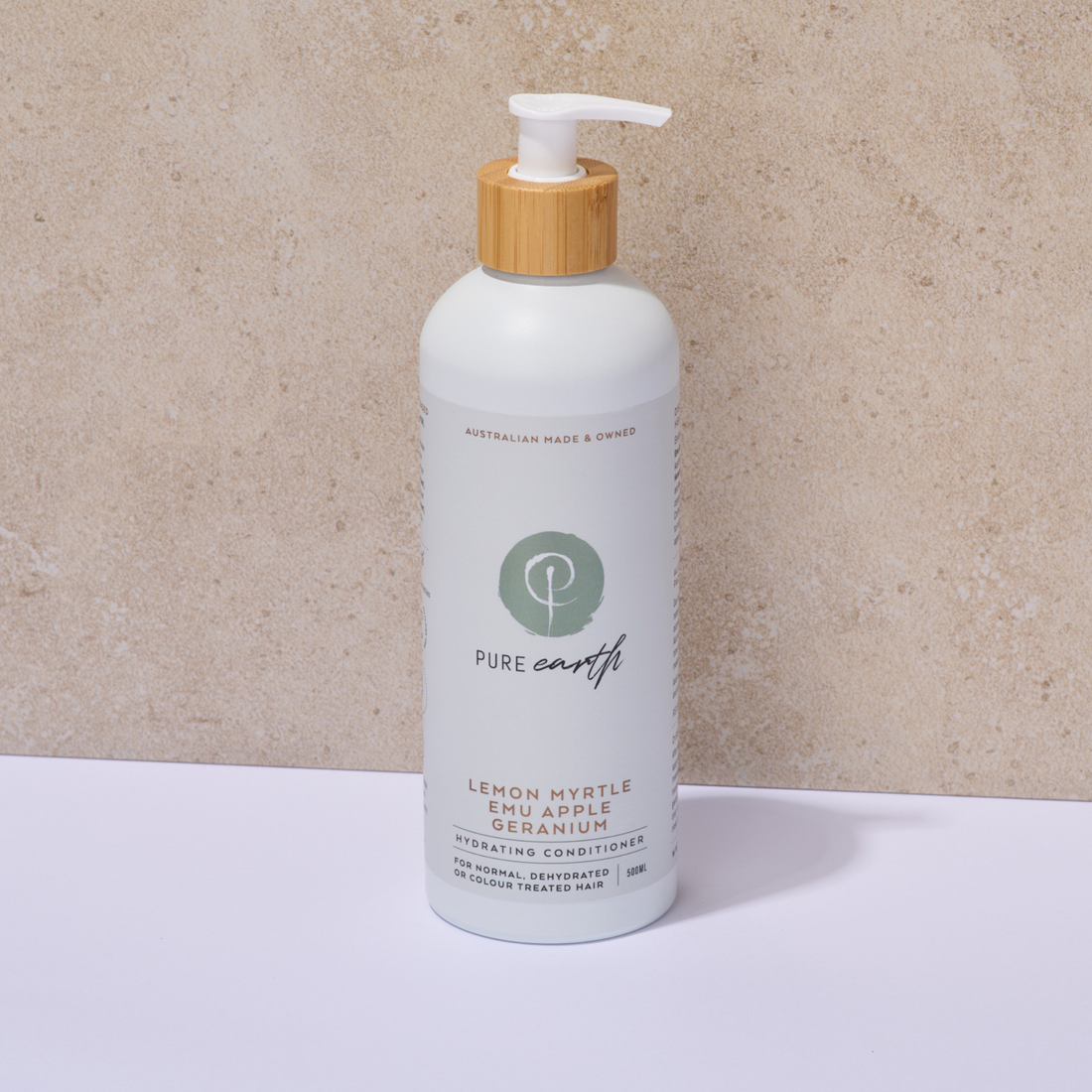White Pure Earth Hydrating Conditioner bottle with a wooden pump on a beige background