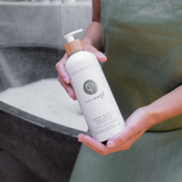 Person holding Pure Earth natural hydrating shampoo plastic free packaging Australia gentle cleansing shampoo for soft healthy hair