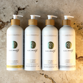 Four bottles of refillable Pure Earth hair care and body care products on a textured stone background