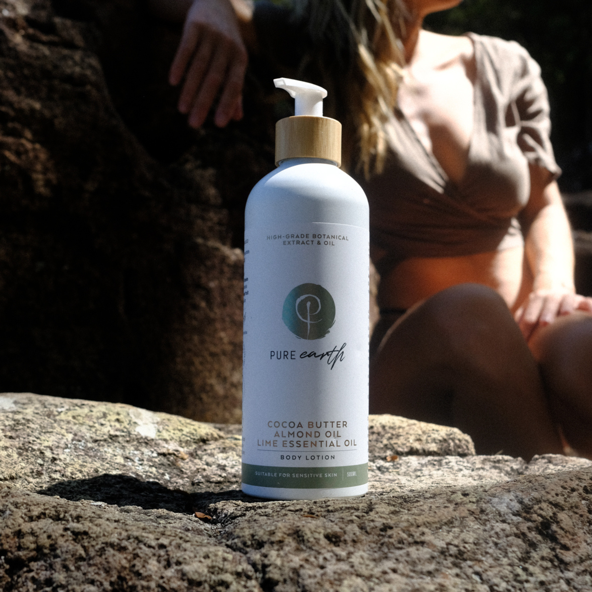 Bottle of Pure Earth skincare product on a rock with a blurred background
