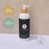 Pure Earth Deep Repair Hair Treatment in a white pump bottle with a bamboo cap, set against a beige textured background on a white surface. Two award badges on the left and a brand seal on the bottom right highlight its Clean + Conscious status.