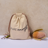 Pure Earth reusable natural linen gift bag with drawstring closure and Pure Earth logo, designed for sustainable Christmas gifting.