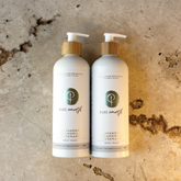 Two bottles of Pure Earth natural body wash on a textured stone background